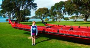 Standing beside a waka (Maori war canoe)