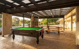 Courtyard dining area and pool table at Hone Heke Lodge backpackers Kerikeri