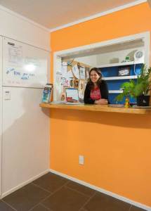 Victoria at reception of Hone Heke Lodge backpackers Kerikeri