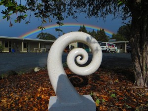 Garden sculpture and beautiful rainbow at Hone Heke Lodge budget accommodation Kerikeri